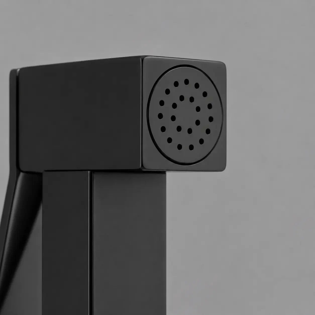 Gros plan sur la tête de douchette WC noir mat avec buses de pulvérisation précises et design carré contemporain. Image