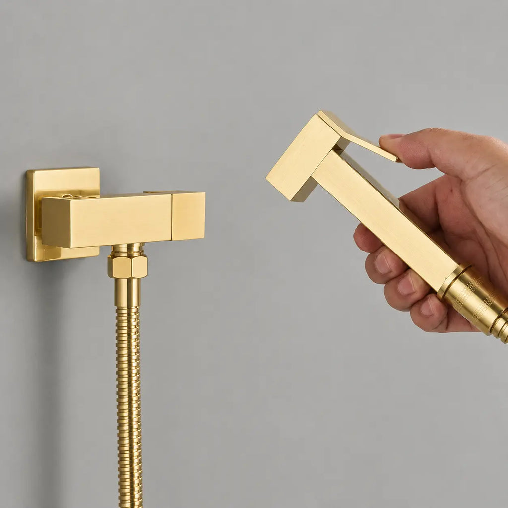 Douchette WC or brossé avec gâchette ergonomique, flexible métallique et robinet mural au design contemporain.