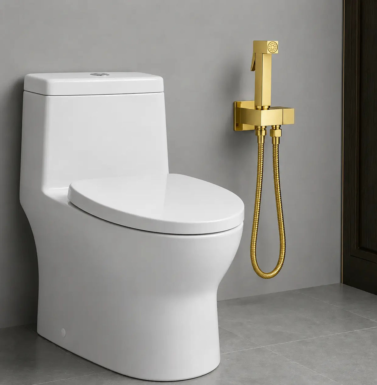 Douchette WC sanitaire dorée montée au mur près d’un toilette moderne, avec flexible métallique et finition or élégante.