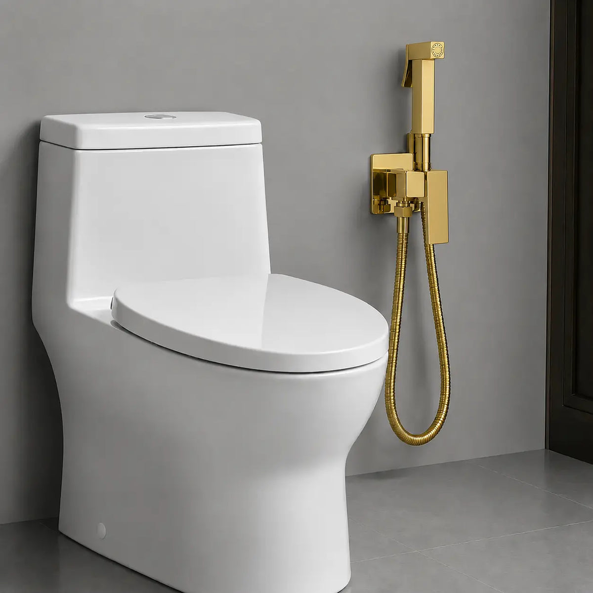 Douchette hygiénique WC finition or installée près d’un toilette moderne, avec flexible métallique et support mural