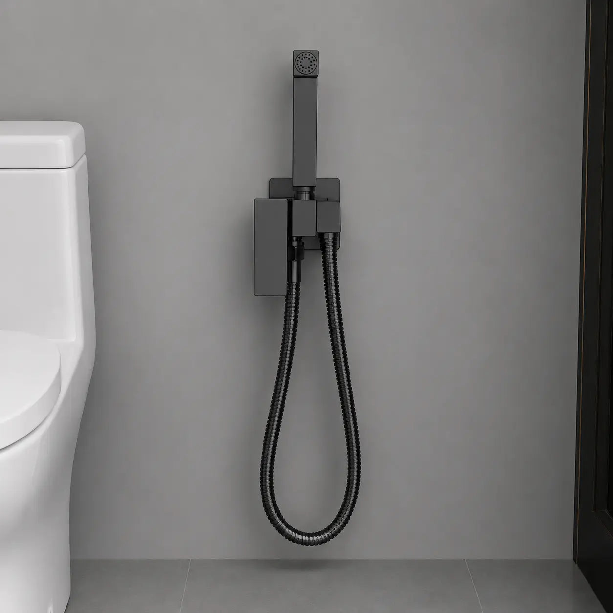 Douchette hygiénique WC noir mat avec flexible suspendu et support mural, installée dans un espace sanitaire moderne. Image
