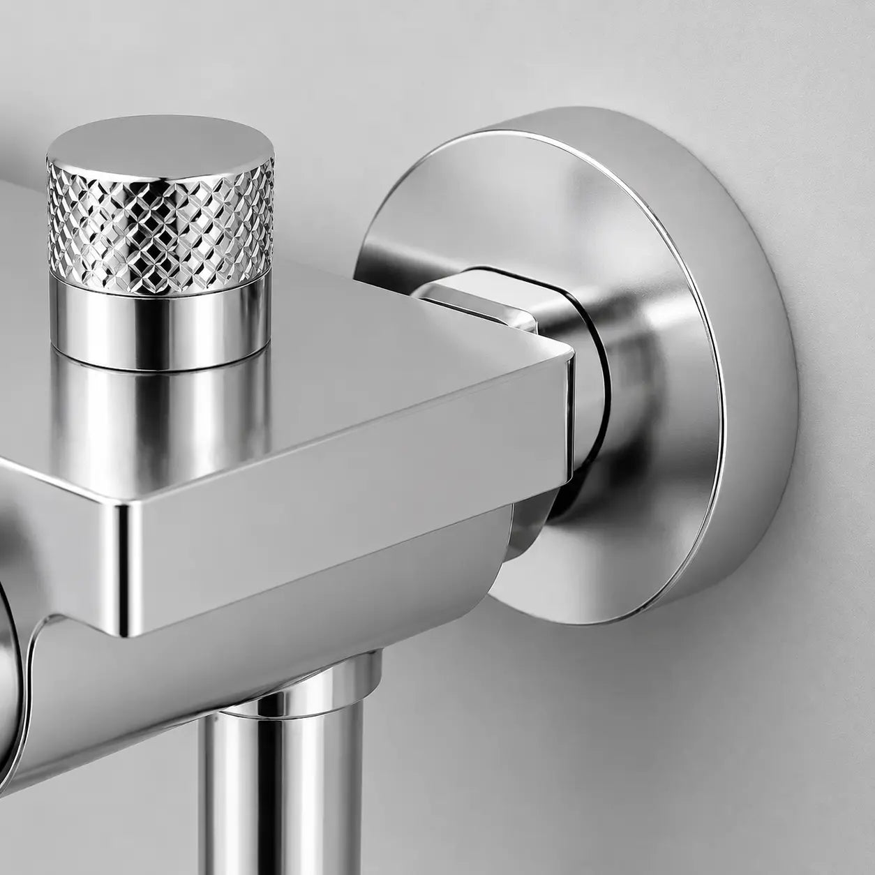 Gros plan sur un mitigeur bain douche mural chromé avec finition brillante, raccord mural discret et molette texturée Image