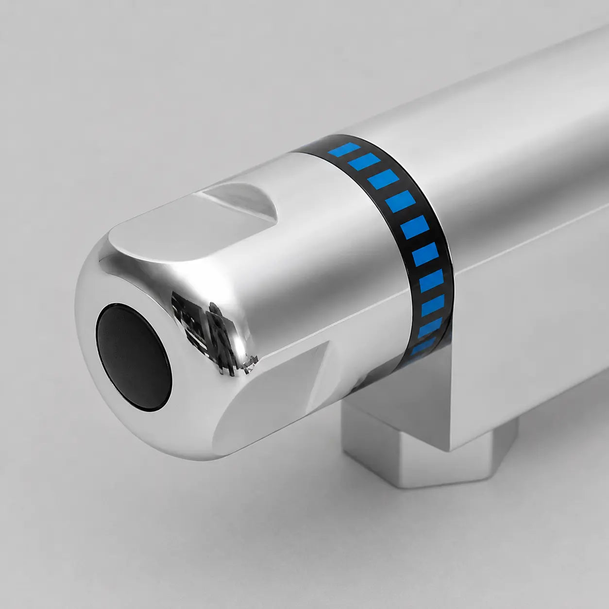 Gros plan sur la poignée de commande chromée avec repères bleus pour le réglage du débit d’un mitigeur thermostatique de douche. Image