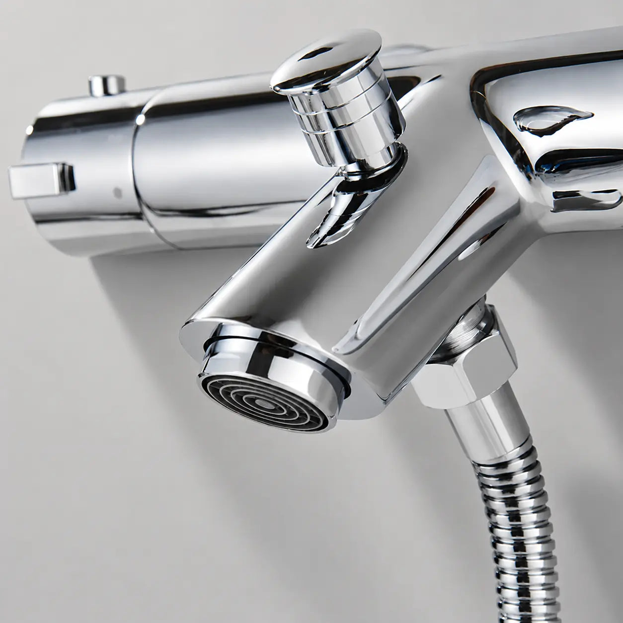 Détail du mitigeur thermostatique chromé Thermivo avec bec moderne, bouton de réglage et flexible de douche Image
