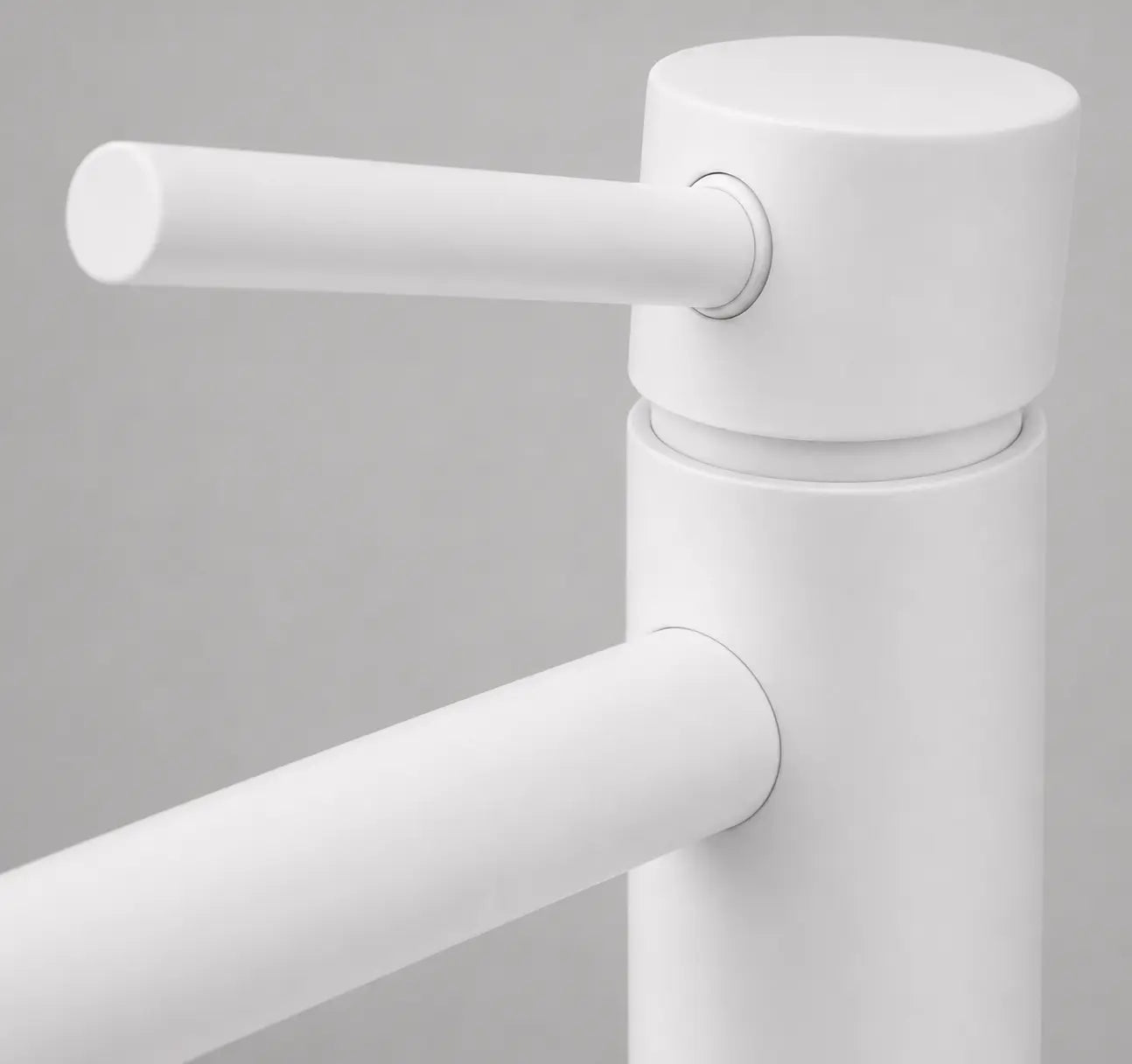 Gros plan sur la commande du robinet mitigeur de vasque blanc, mettant en avant son design cylindrique minimaliste et sa finition mate. Image