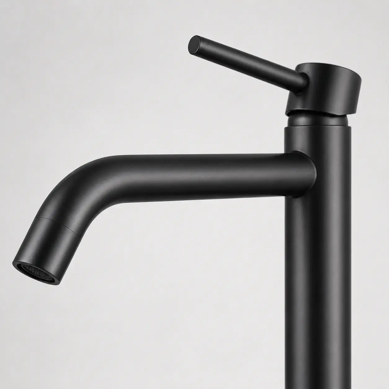 Gros plan sur un robinet mitigeur haut noir mat, design minimaliste avec bec incurvé et levier fin pour vasque moderne. Image