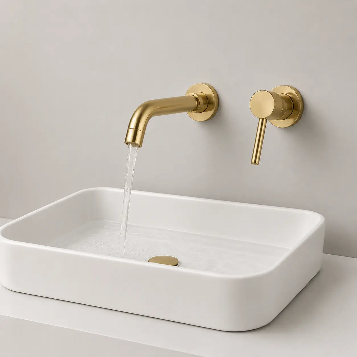 Robinet mural encastré or brossé avec écoulement d’eau sur vasque blanche au design moderne et épuré