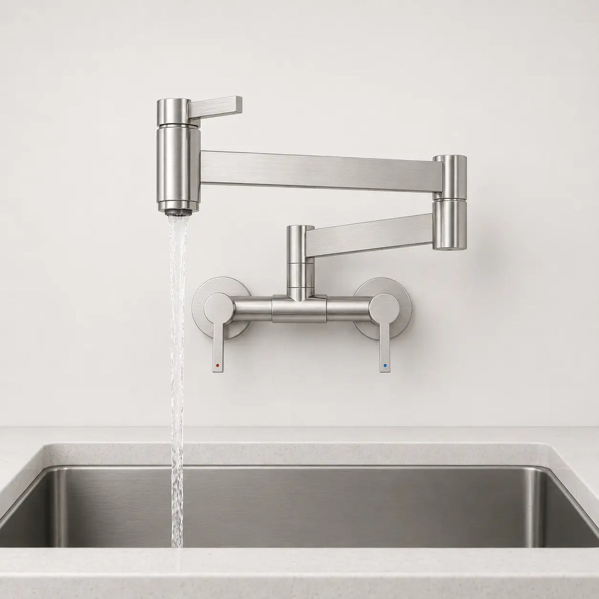 Robinet mural rabattable de cuisine en nickel brossé avec bras articulé pivotant, double levier et jet d’eau en usage