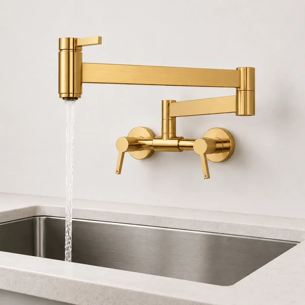 Robinet mural rabattable de cuisine en or brossé avec bec articulé pivotant, jet d’eau en fonctionnement au-dessus de l’évier