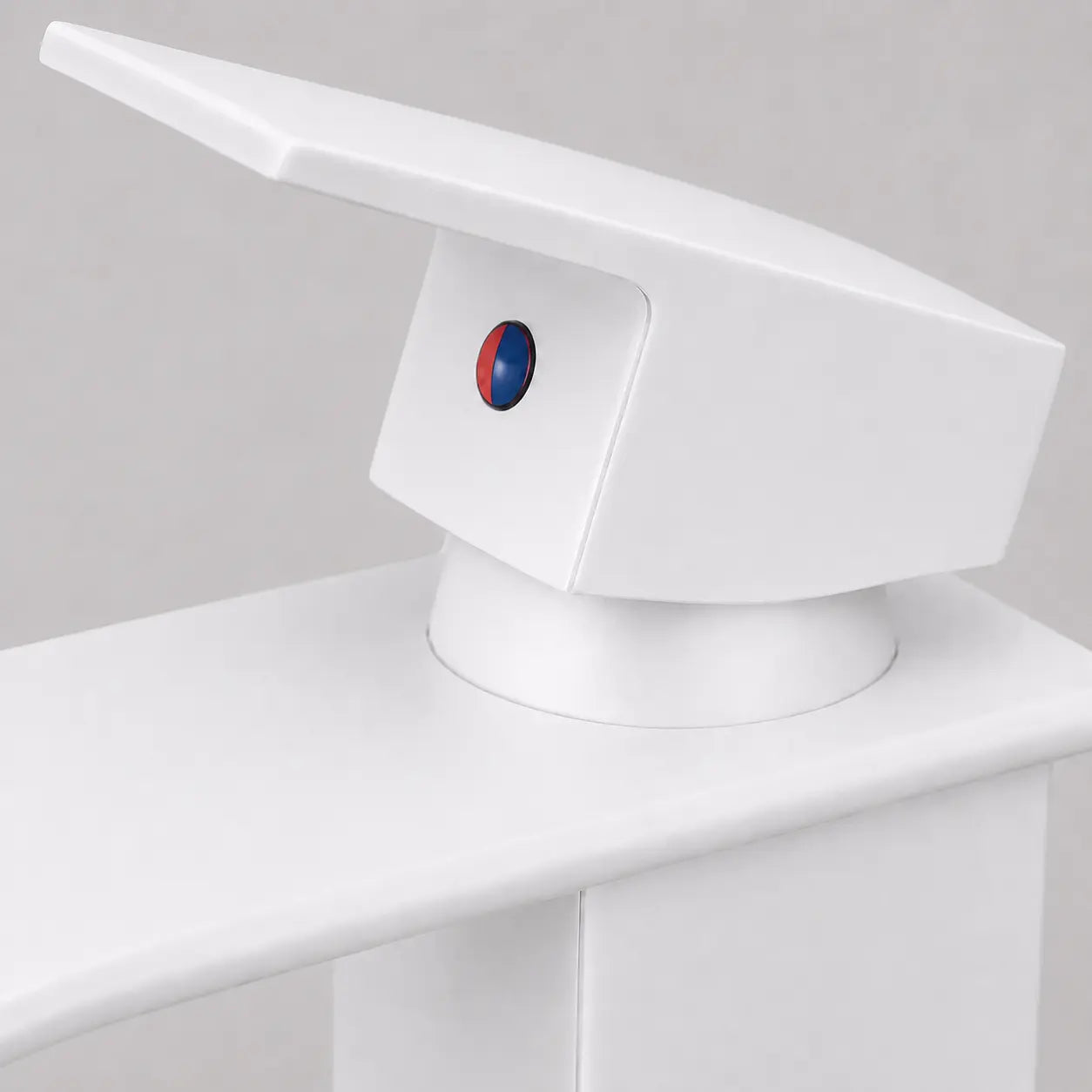  Gros plan sur la commande monolevier d’un robinet de vasque blanc au design moderne, avec indicateur chaud et froid intégré. Image
