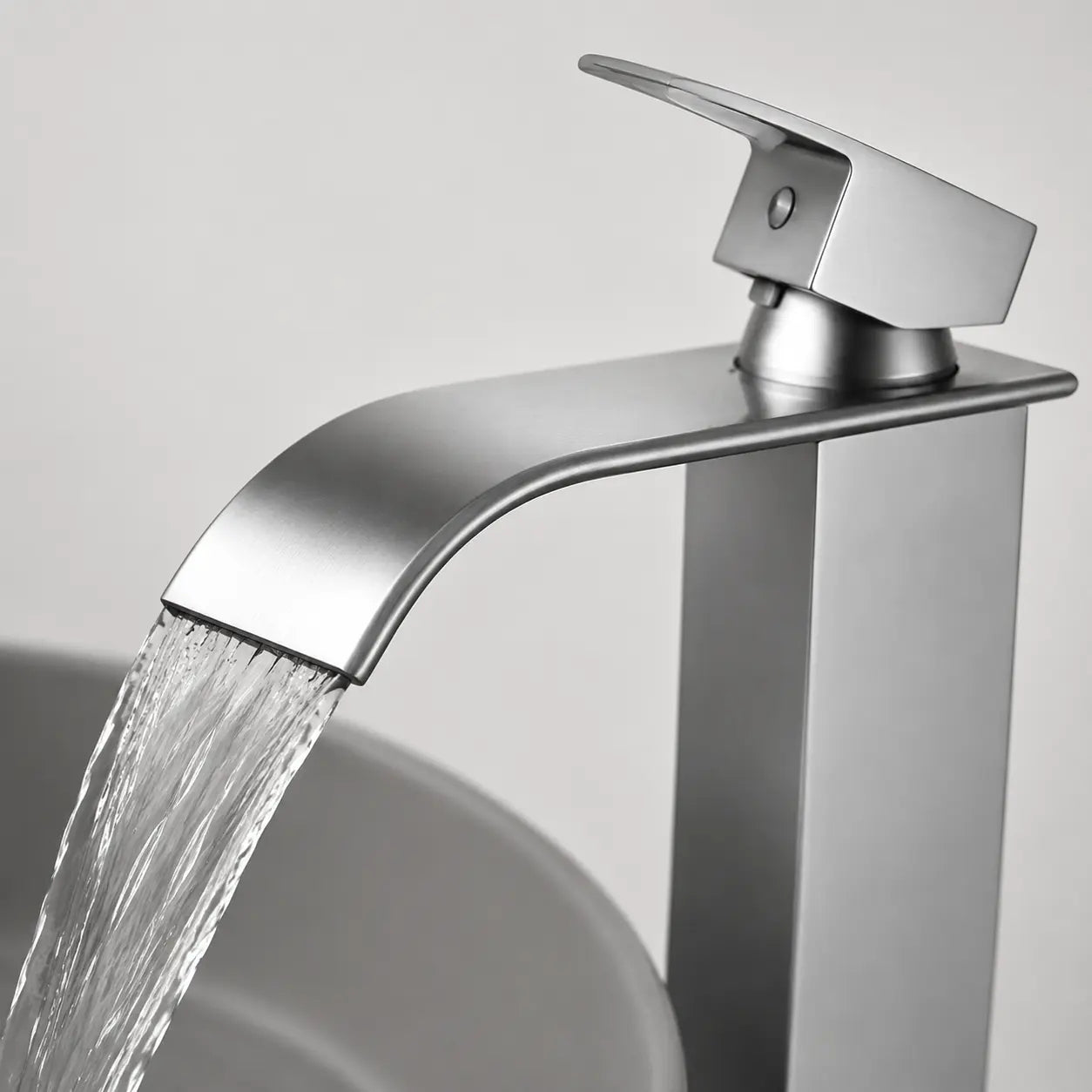 Gros plan d’un robinet de vasque moderne chromé avec bec cascade en fonctionnement, écoulement fluide et design contemporain élégant Image