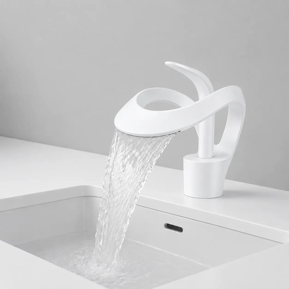 Robinet de lavabo cascade blanc en laiton en fonctionnement, avec écoulement large effet cascade et design contemporain épuré.