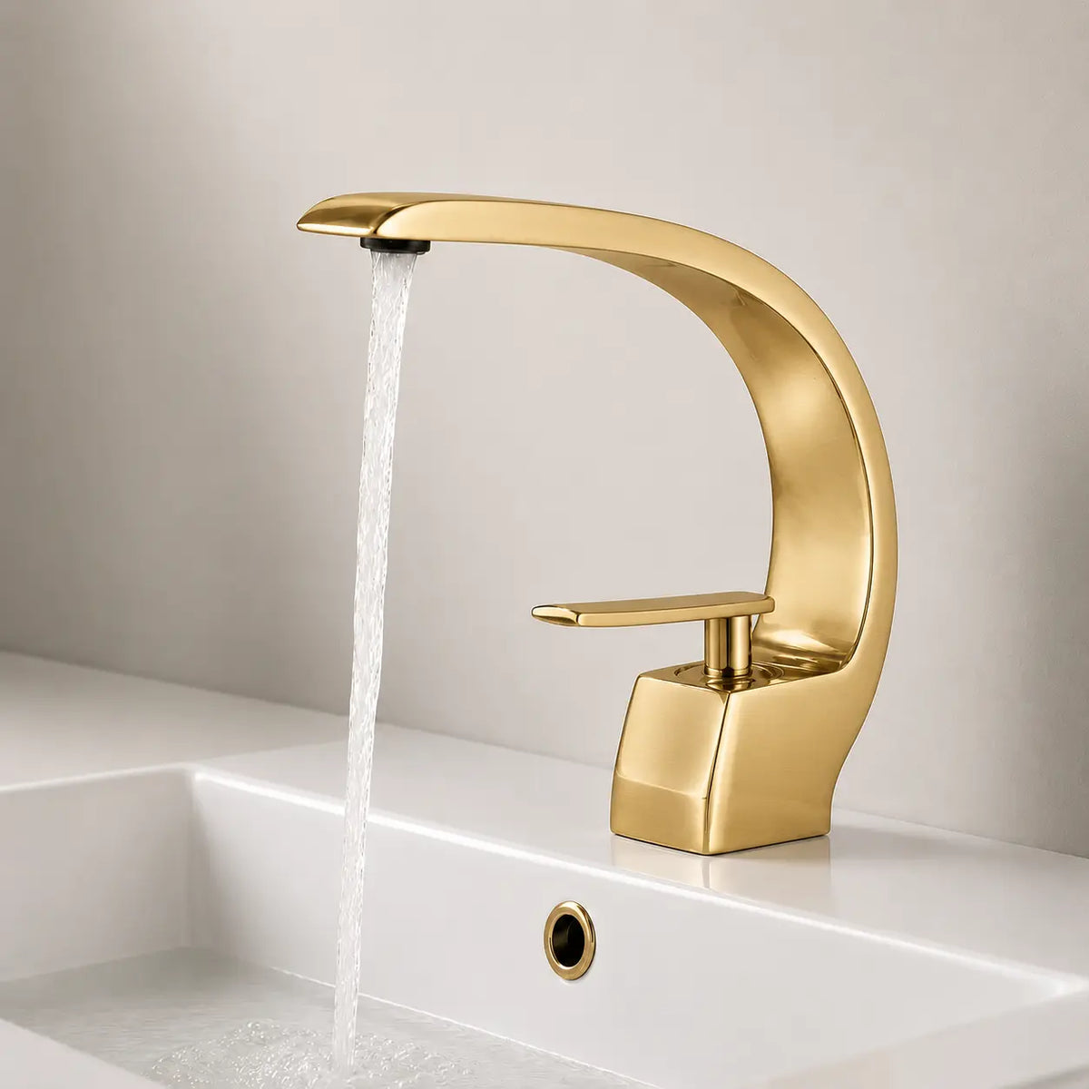 Robinet de lavabo en or brossé en fonctionnement, design arqué élégant avec jet d’eau fluide et commande monocommande.