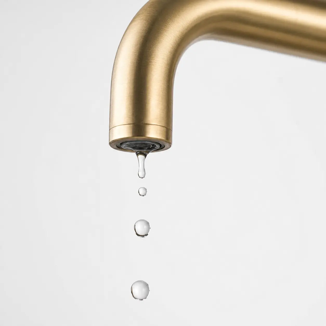 Robinet moderne en laiton brossé avec gouttes d’eau tombantes sur fond gris minimaliste Image