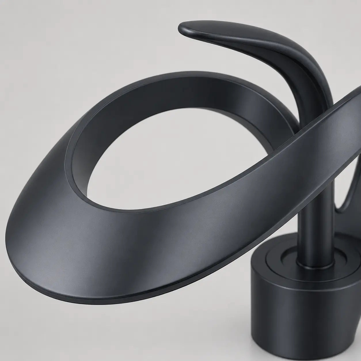 Gros plan sur robinet de lavabo noir mat en laiton, design sculptural avec bec cascade pour salle de bain moderne Image