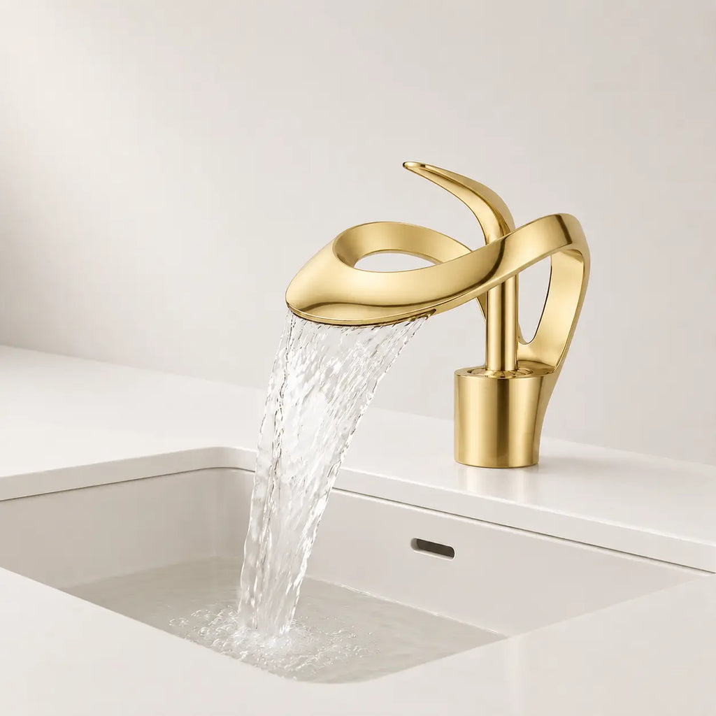 Robinet de lavabo cascade en laiton doré mat en fonctionnement, design sculptural avec large jet d’eau fluide