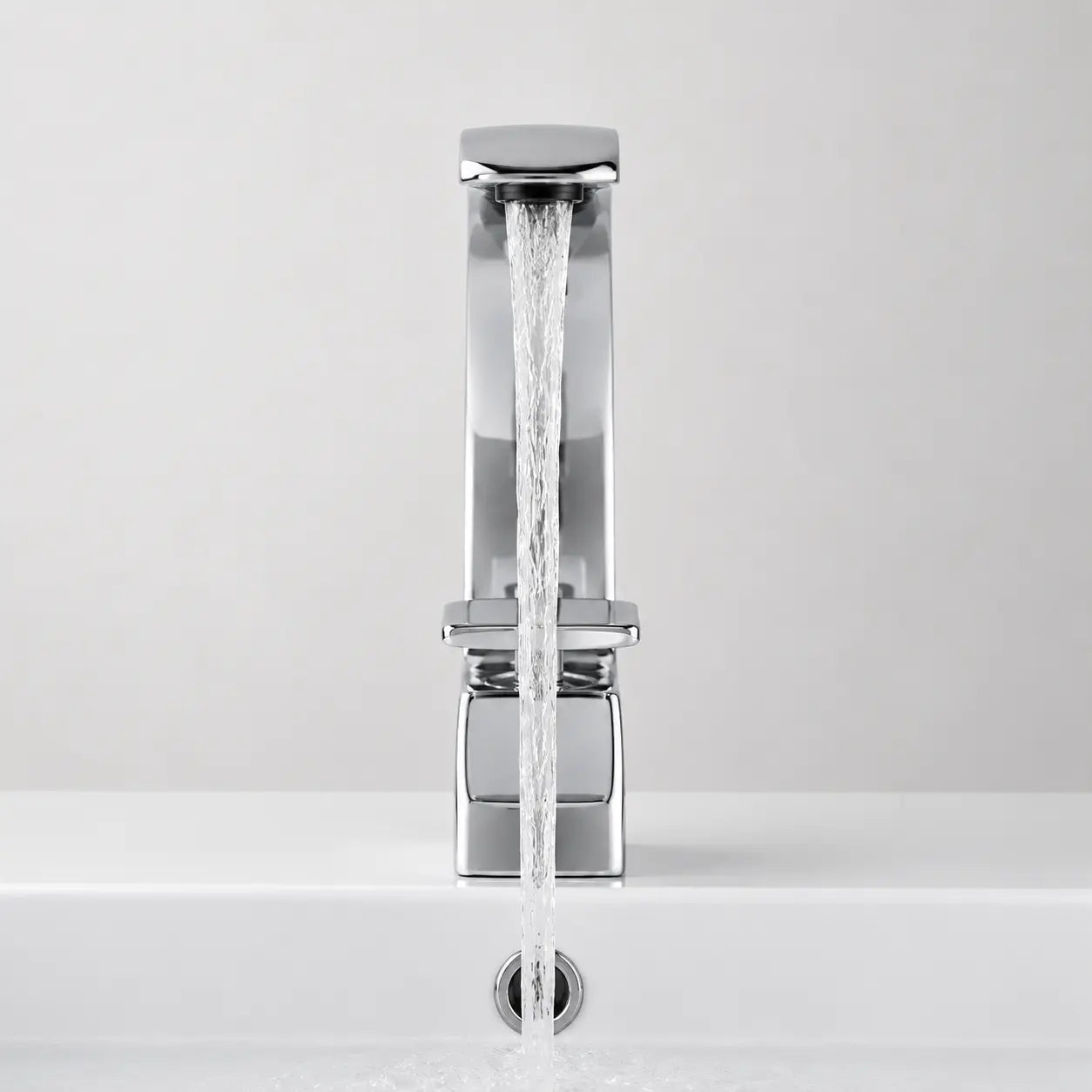 Vue frontale du robinet mitigeur de lavabo chromé en fonctionnement, avec jet d’eau fluide et design moderne épuré. Image