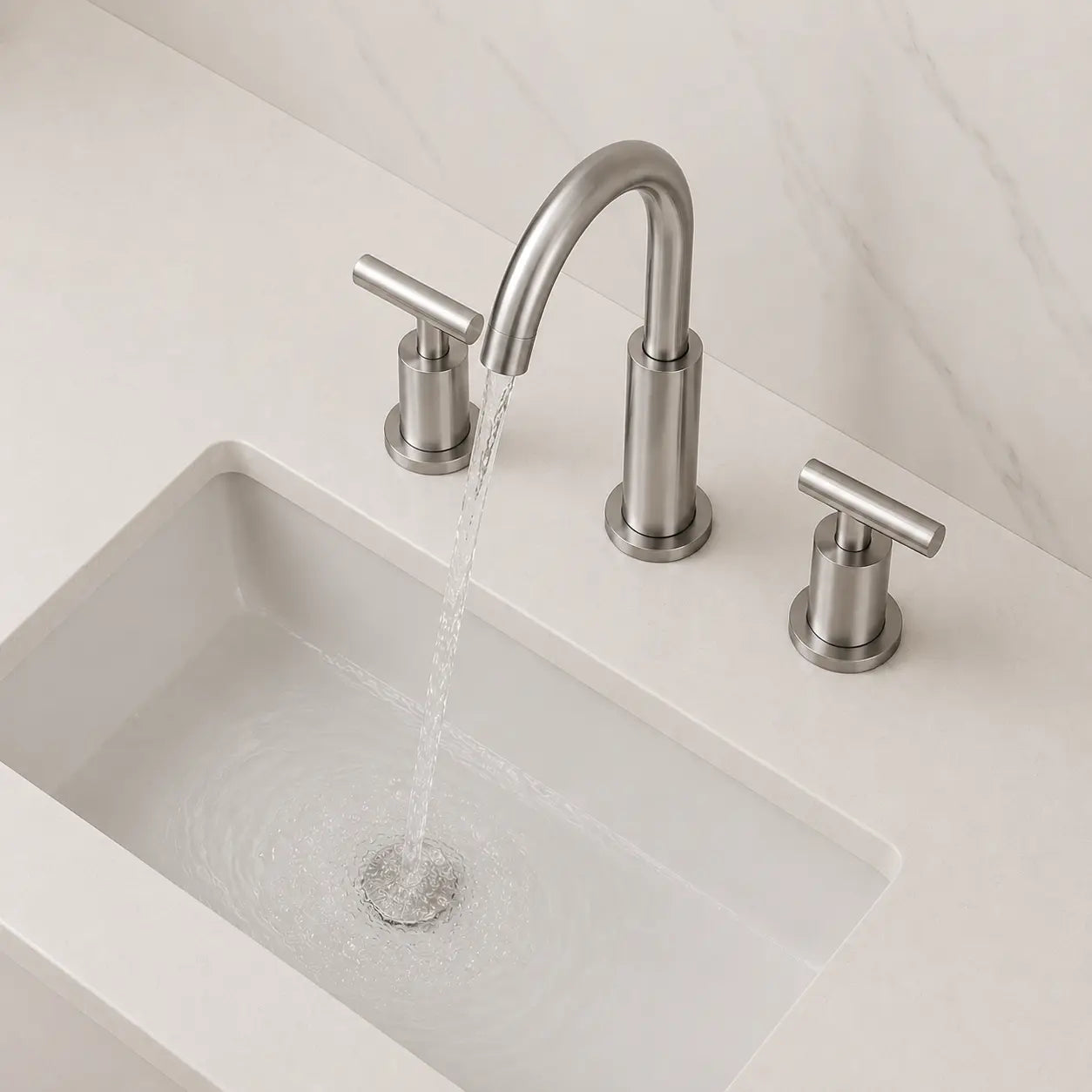Robinet de lavabo 3 trous en acier inoxydable brossé en fonctionnement avec bec incurvé et design moderne minimaliste Image