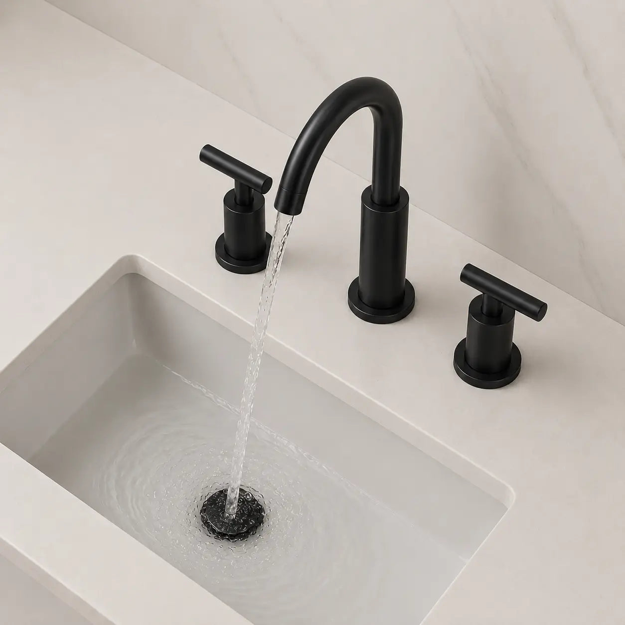 Robinet de lavabo noir mat à 3 trous avec bec incurvé et poignées en T, en fonctionnement sur vasque moderne. Image
